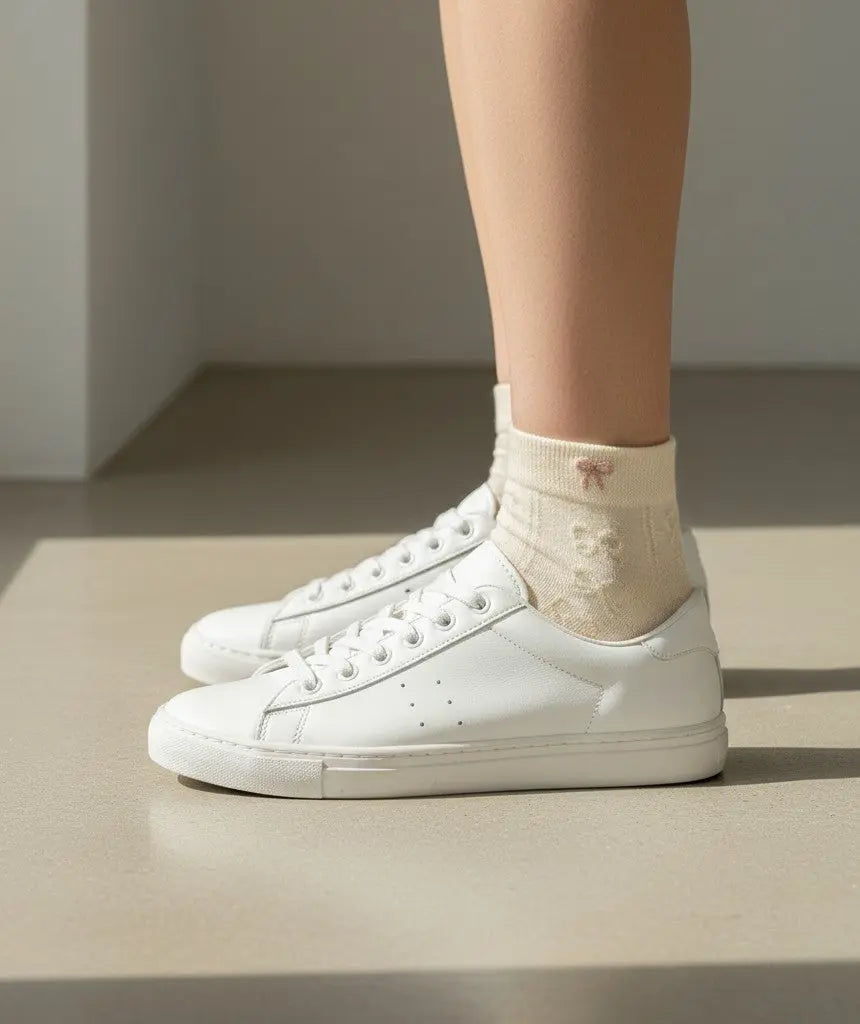Chaussettes courtes SOXX.shop en coton beige avec un petit nœud décoratif portées avec des baskets blanches